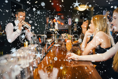 Handsome bartender making cocktails for beautiful women