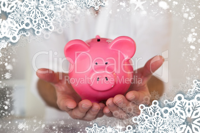 Composite image of casual businessman holding piggy bank