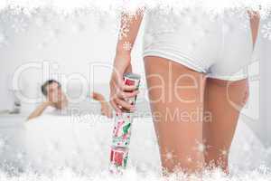 Composite image of sexy woman bringing christmas cracker to her