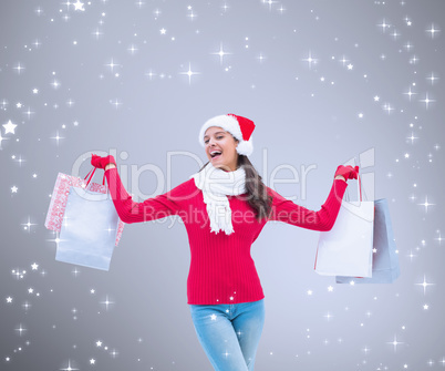 Composite image of festive brunette holding shopping bags