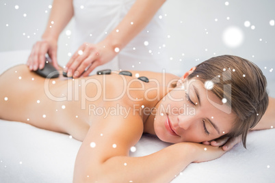 Beautiful woman receiving stone massage at spa center