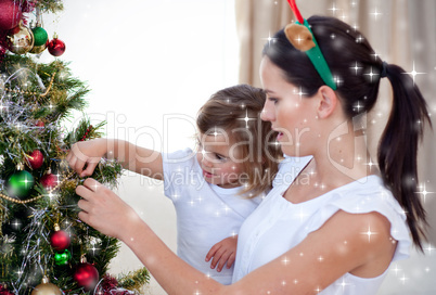 Mother and daughter decorating a christmas tree