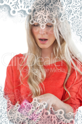 Composite image of surprised woman opening her gift