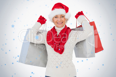Festive woman smiling at camera holding shopping bags
