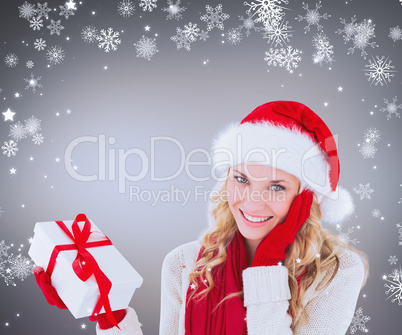 Composite image of happy festive blonde with gift