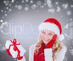 Composite image of happy festive blonde with gift