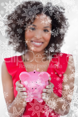 Composite image of piggy bank being held by a brunette woman