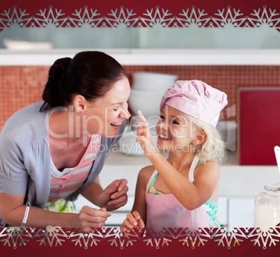 Smiling mother and her daughter baking in a kitchen