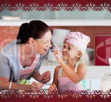 Smiling mother and her daughter baking in a kitchen