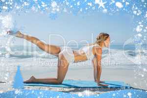 Gorgeous fit blonde in pilates pose on the beach