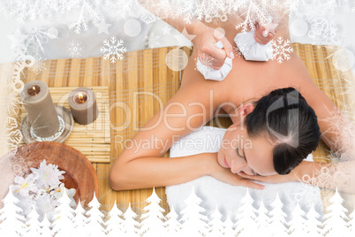 Peaceful brunette enjoying a herbal compress massage