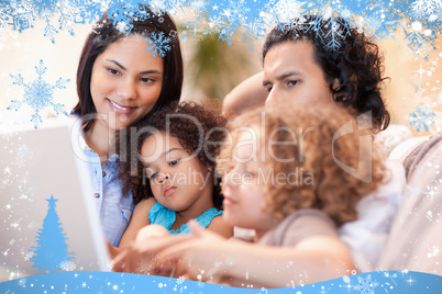 Composite image of happy family using laptop together