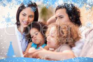 Composite image of happy family using laptop together