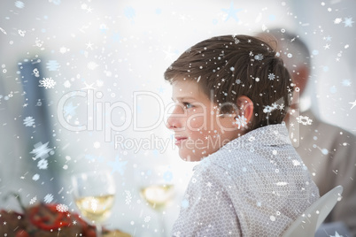 Composite image of side view of a little boy at table