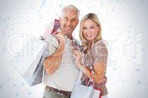 Happy couple holding shopping bags and credit card