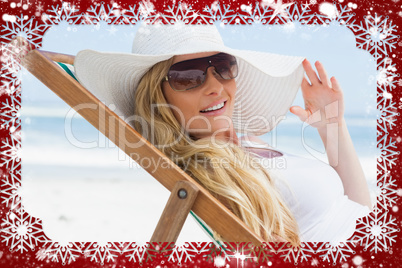 Gorgeous blonde sitting at the beach wearing sunhat and sunglass