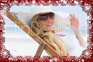 Gorgeous blonde sitting at the beach wearing sunhat and sunglass