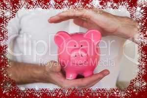 Composite image of casual businessman holding piggy bank