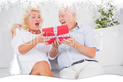 Composite image of surprising old woman receiving a gift