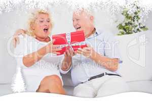 Composite image of surprising old woman receiving a gift