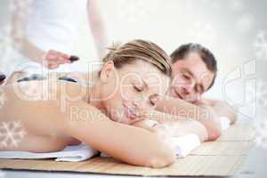 Young couple having a massage with hot stone