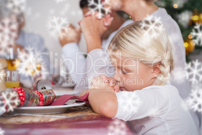 Family saying grace before dinner