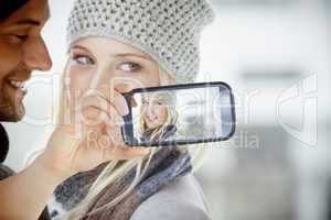 Composite image of hand holding smartphone showing