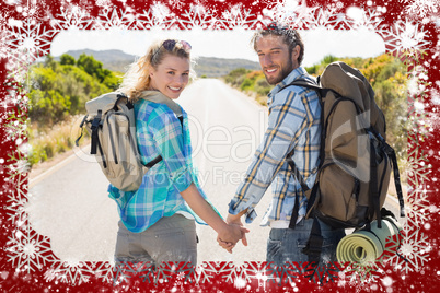 Attractive couple standing on the road holding hands smiling at