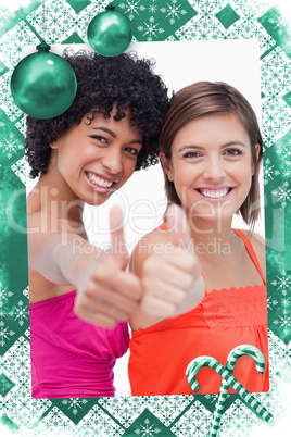 Smiling teenage girls proudly showing their thumbs up against a white background