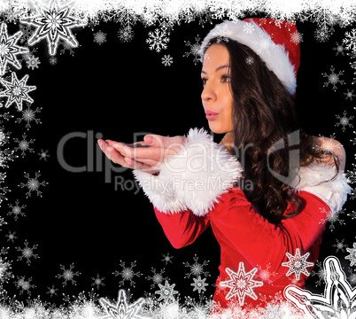 Pretty brunette in santa outfit blowing over her hands