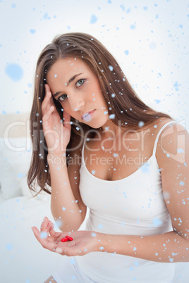 Woman looking straight ahead and worried about taking the two pills