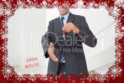 Businessman offering a handshake while holding up keys