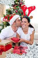 Composite image of smiling couple giving presents for christmas