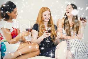 Cheerful female friends with wine glasses enjoying a conversatio