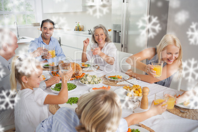 Composite image of happy family raising their glasses together