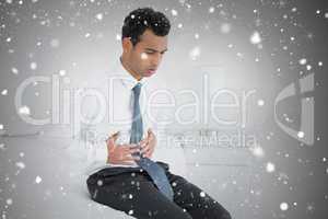 Composite image of businessman with stomach pain sitting on bed