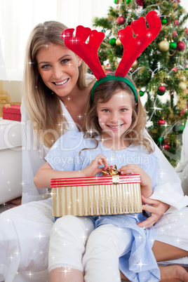 Composite image of smiling mother and her daughter unpacking chr