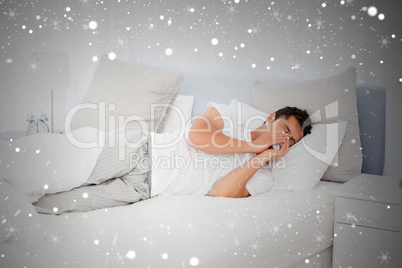 Composite image of sick man blowing his nose lying on his bed