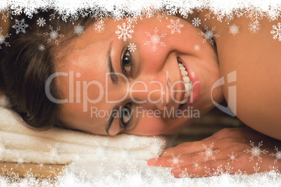 Happy brunette lying in a sauna looking at camera