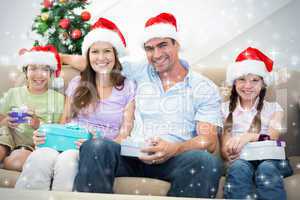 Composite image of happy family with christmas presents