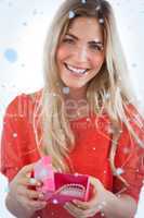 Composite image of smiling woman with gift box