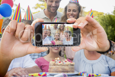 Composite image of hand holding smartphone showing