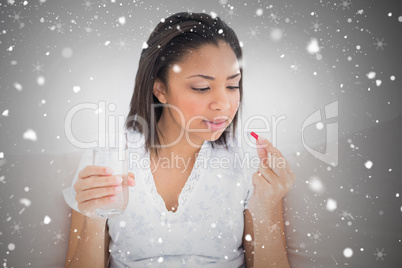 Unsmiling young dark haired model taking medication