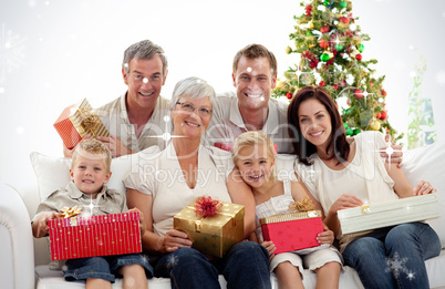 Composite image of family holding christmas presents at home