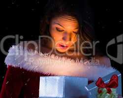 Composite image of pretty brunette in santa outfit opening gift