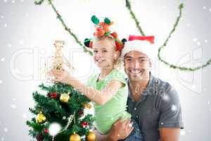 Happy father and daughter decorating together the christmas tree