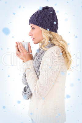 Pretty blonde in winter fashion holding mug