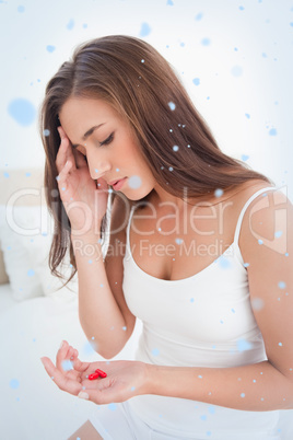 Woman looking worried as she decides whether or not to take the tablets