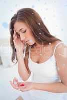 Woman looking worried as she decides whether or not to take the tablets