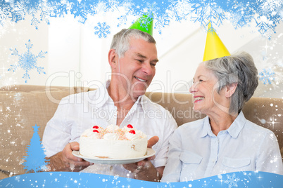 Senior couple sitting on couch celebrating a birthday